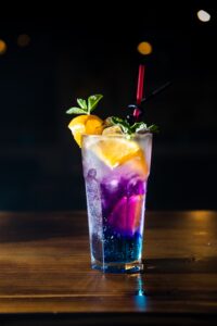 Boozi Babe colorful cocktail in highball glass with tropical garnish